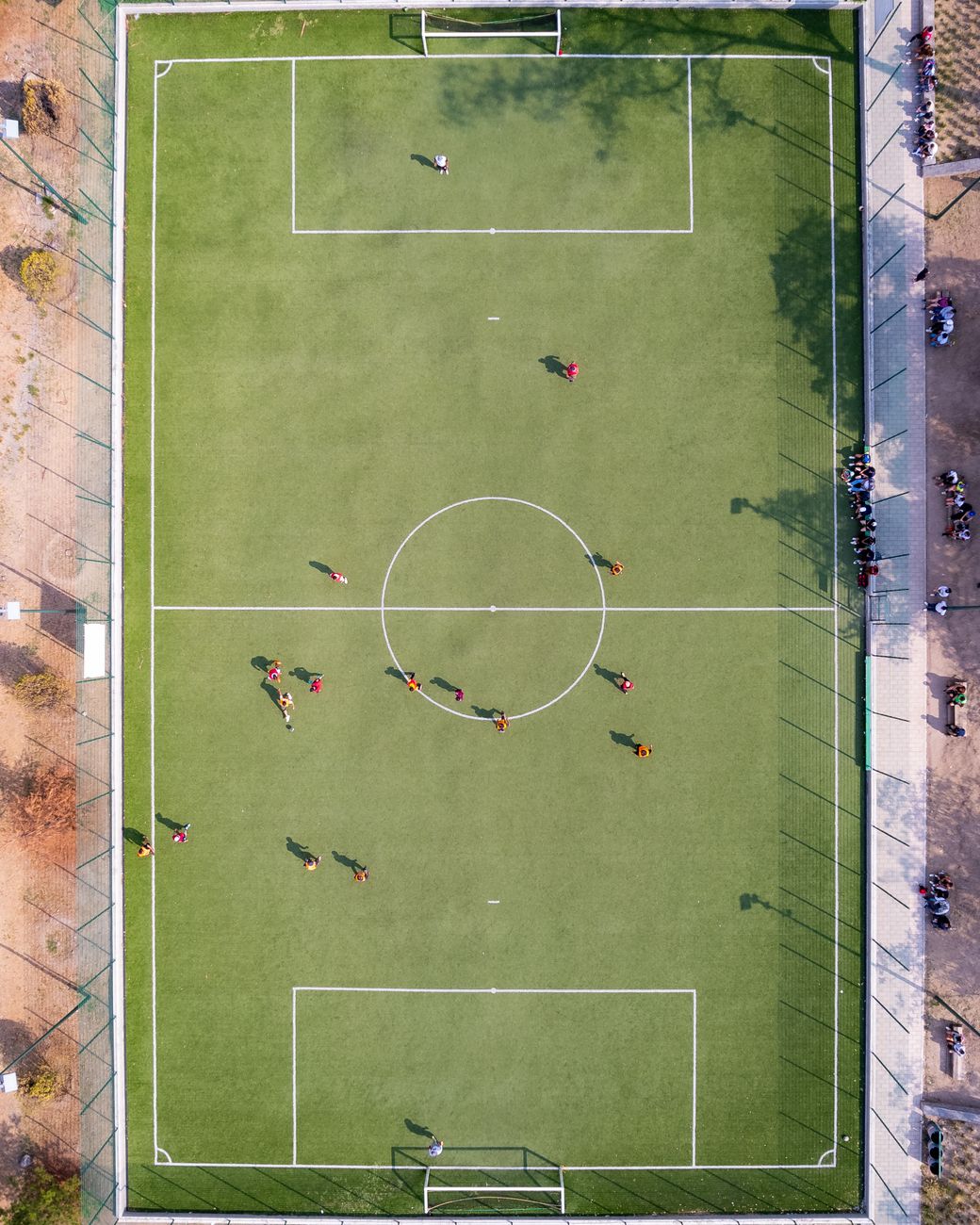 Aerial shot capturing a soccer match on a grass field in Ciudad de México.